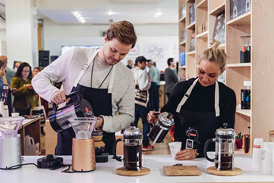 Two baristas make coffee using Bodum french presses at The New york Coffee Festival.
